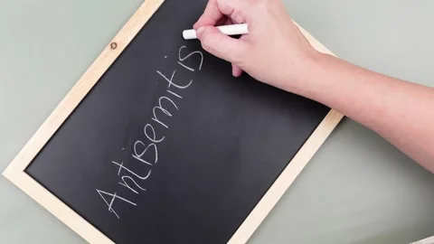 Antisemitism minimalistic concept. Hand is writing Word Antisemitism Stock Footage 260232399