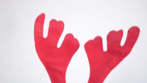 The antlers of the deer appear playfully from side to side on a white background Stock Footage 166304299