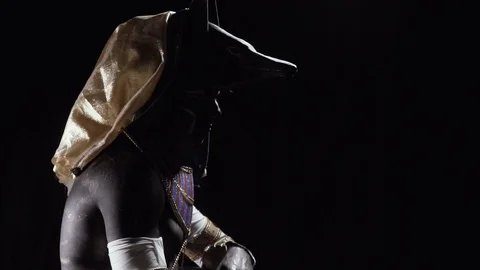 Anubis is sitting in dramatic lighting and beckoning with his hand Video stock 115477415