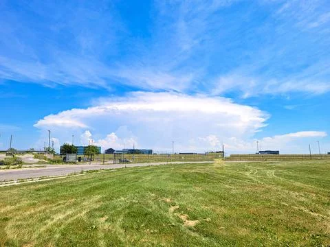 Anvil-Shaped Storm Cloud Towering Over Airport Perimeter Stock Photos