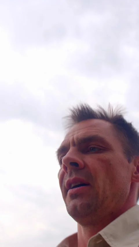 Anxious expressions overcast sky, windblown leaves, beige shirt Stock Footage 325671028