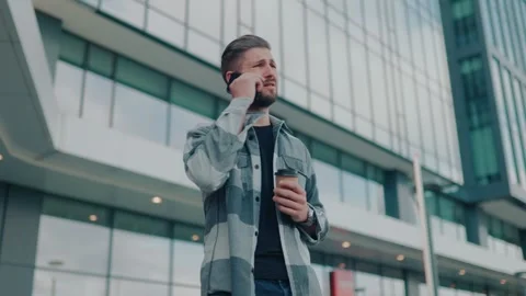 Anxious Guy with Beard Communicating on Mobile Phone in the City Stock-Footage 252355346