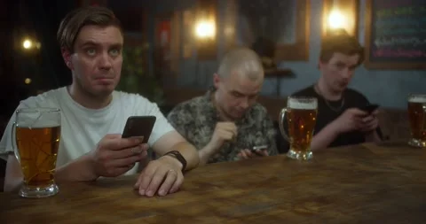 Anxious man checking bets on cellphone, watching sports in bar, bookmaker app Stock Footage 157739446