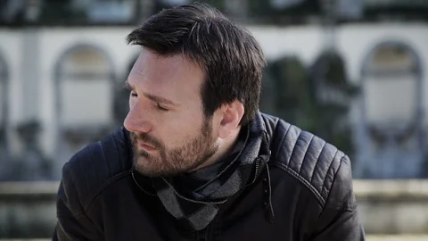 An anxious man covers his face with his hands in the park  Video stock 102281884