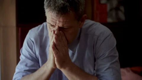 Anxious man with headache covers his face with his hands Stock Footage 100926281