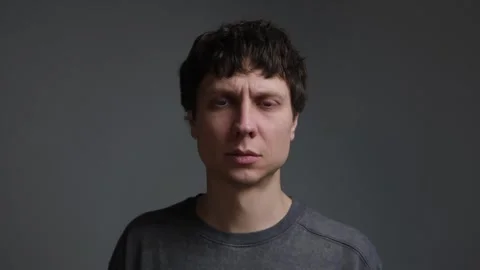 Anxious man looking into camera then lowering gaze. Portrait of stress, worry Stock-Footage 323217045