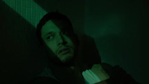 Anxious Man in Shadow Seeks Solace in Dimly Lit Room Stock Footage 319758586