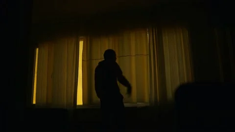 An anxious man standing in front of a closed window in the Darkroom. Stock Footage 169448762