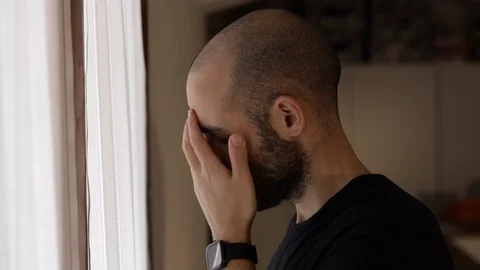 Anxious man thinks in front of the window. Face depressed of caucasian man Stock Footage 125528029