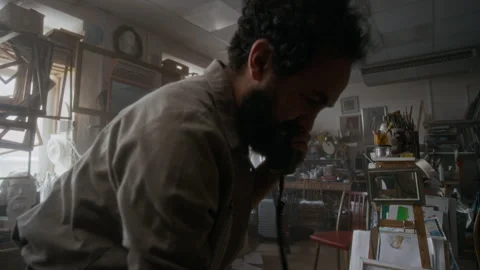 Anxious Painter Rummaging through Sketches and Calling on Phone in Art Studio Stock Footage 334686082