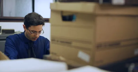 Anxious professional man working and feeling stressed behind boxes of files in i Stock Footage 199455340
