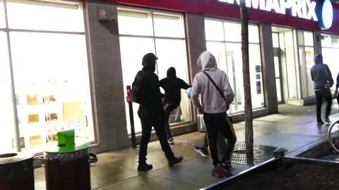Anxious store workers look afraid while rioters break their storefront windows Stock Footage 137553137