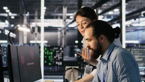 Anxious technicians in data center reacting to system lockdown caused by hacker Stock Photos