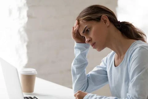 Anxious worker sitting at desk looking at computer screen Stock Photos