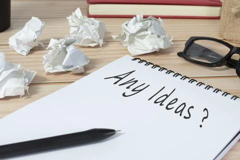 Any ideas question written on notepad with trash paper background on office.. Stock Photos