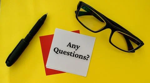 Any questions text on white notepad with pen, glasses and alarm clock on yellow Stock Photos
