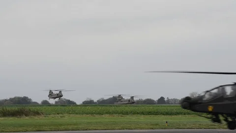 Apache helicopter lands as CH-47F Chinooks take off Stock Footage 113297354