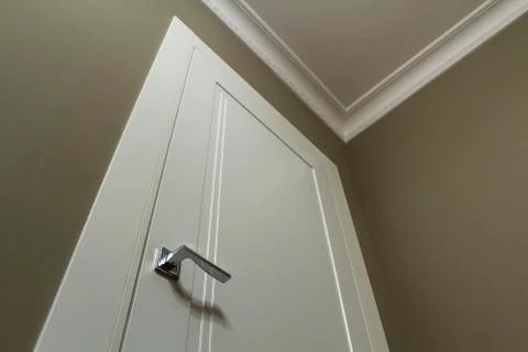 Apartment after renovation interior. White door with metal handle, light wall Stock Photos