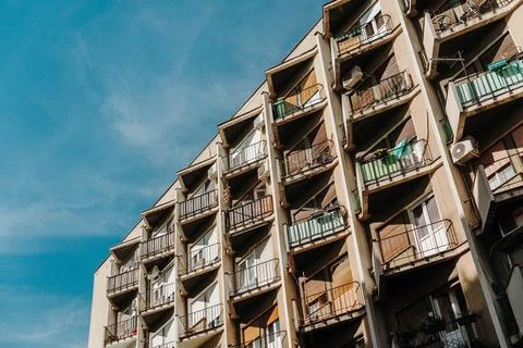 Apartment block with rows of balconies rises under a blue sky in Novi Sad Ser Stock Photos