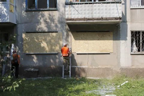 An apartment building with the aftermath of a rocket attack and temporary w.. Stock Photos