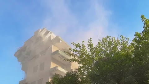 Apartment building collapsing with heavy dust cloud during demolition Stock Footage 332683630