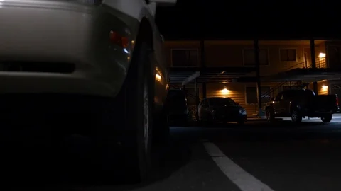 An apartment building at night from parking lot Stock Footage