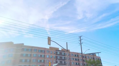 Apartment building rooftop view with power lines under a bright blue sky, Video stock 318311147