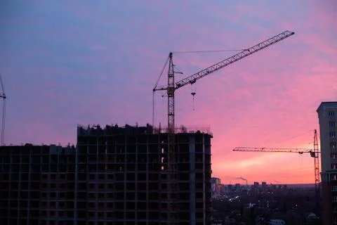 Apartment building site and crane in the city in sunrise Stock Photos