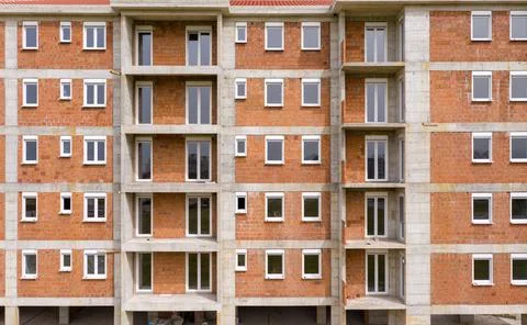 Apartment building under construction: outer wall made of bricks ready for Stock Photos