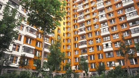Apartment complex of bright orange color with many trees in the yard Stock Footage 223129682