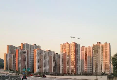 Apartment complex by the highway under sunset Stock Photos