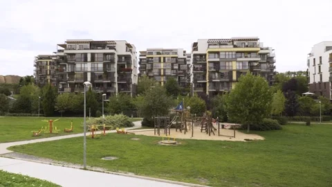 An apartment complex with a playground and an outdoor gym in the foreground Stock Footage 277908069