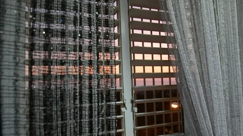 Apartment curtained window with city view in the evening. Looking out the window Видео 115664978
