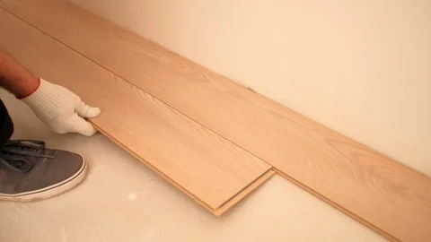 Apartment renovation. Builder installing wood flooring Stock Footage