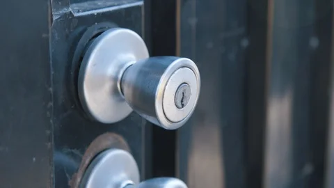 Apartment security gate handle unlocked by keys in neighborhood Stock Footage 89226420