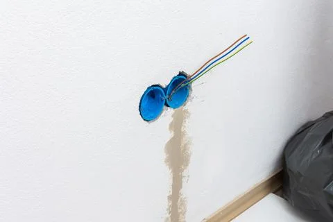 Apartment wall preparation for electrical outlets includes blue conduit box.. Stock Photos