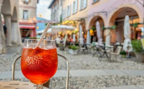 Aperol Spritz served on a table with a charming Italian historic town in the Foto stock