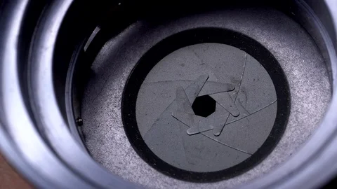 Aperture or iris mechanism in rotation. Camera lens aperture close up. Stock Footage 99375262