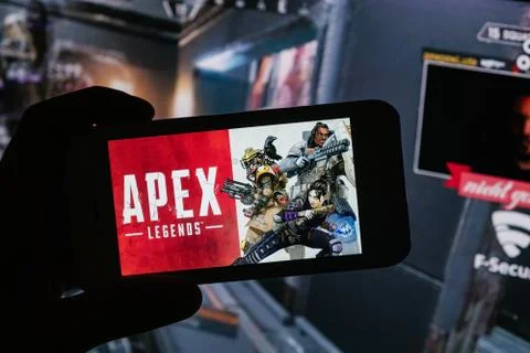 Apex Legends logo is displayed on mobile phone hold by a young boy who plays Stock Photos