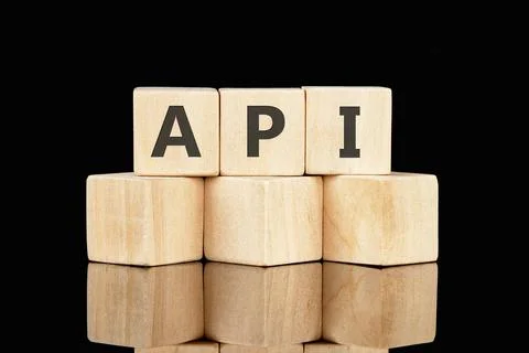 API abbreviation, modern technology concept. API made of wooden cubes on a bl Stock Photos