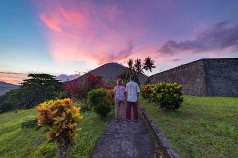 Api volcano at sunset, couple looking at view from Banda Naira fort, Maluku M Stock Photos