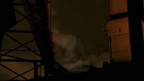 Apocalyptic industrial scape at night lit up by unseen truck Stock Footage 89945404