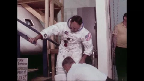 Apollo 11 Astronaut Michael Collins having rubber over shoes removed from feet Stock Footage 269506630