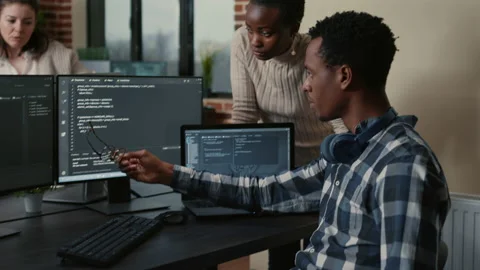 App developer removing glasses while explaining algorithm to colleague programer Stock Footage 168237733