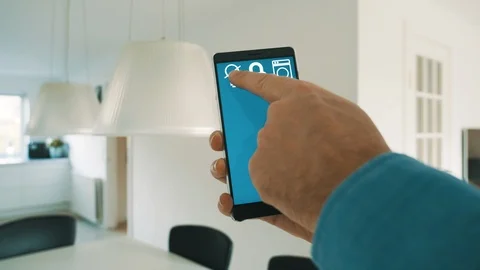 App on mobile phone controls smart home and turns on lights bulbs in lamp Stock Footage 101832413