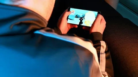 App on smart phone shows action game and man controls and plays it Stock Footage 101080955