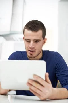 This app is so cool. A young man exploring his new technological purchase. Stock Photos