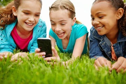 This app is so much fun. Three little girls spending time together and sharing a Stock Photos