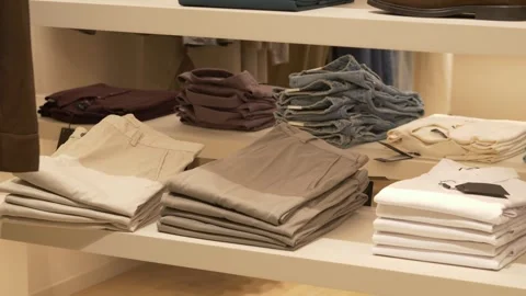 Apparel store interior with folded polo shirts on display table. Modern retail Stock Footage 317317290