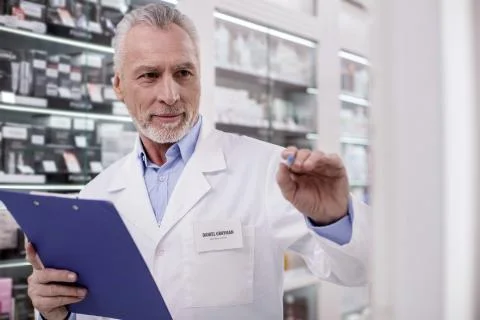 Appealing male pharmacist compiling list Stock Photos
